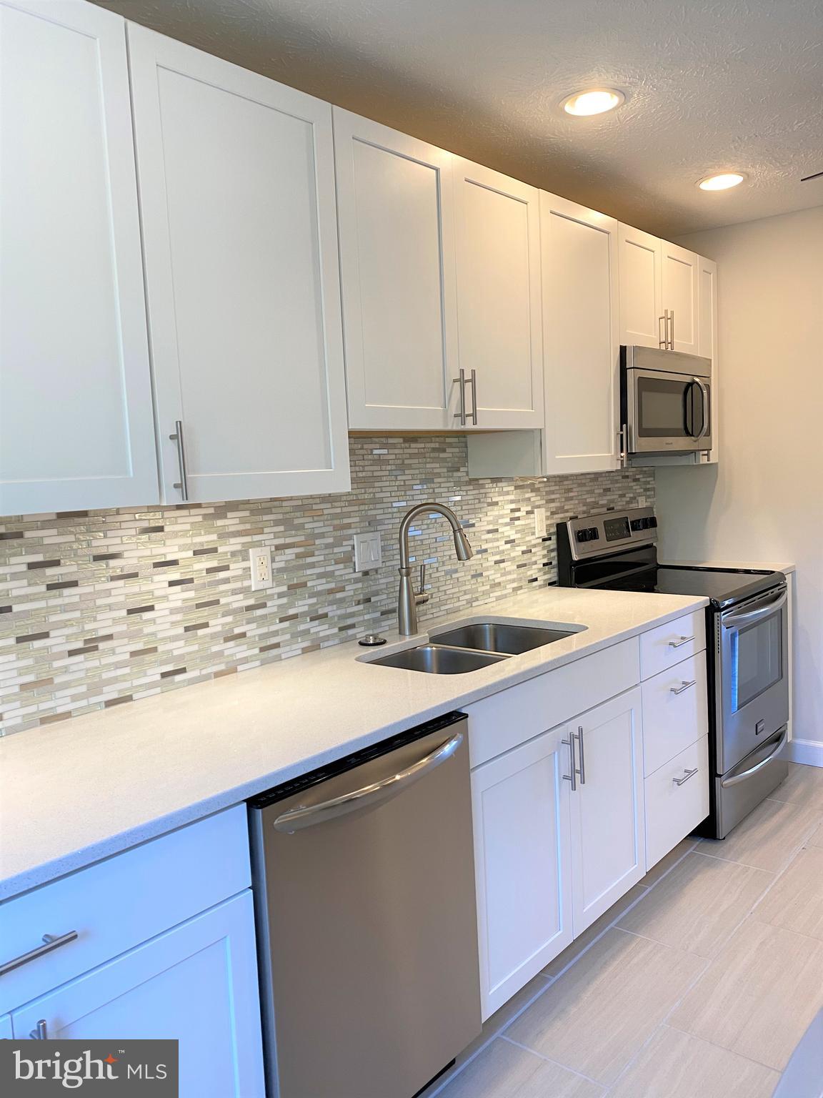 3933 Cutty Sark Road Baltimore, MD 21220 - Photo 25 of 69 a kitchen with stainless steel appliances granite countertop a sink a stove and a microwave oven