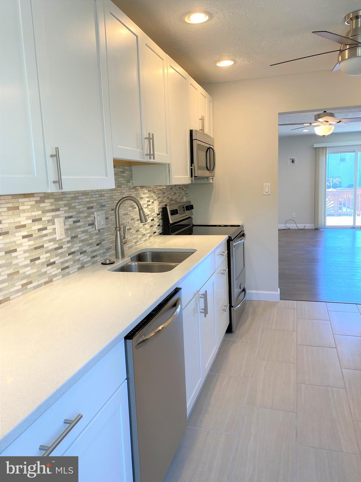 3933 Cutty Sark Road Baltimore, MD 21220 - Photo 26 of 69 a kitchen with stainless steel appliances granite countertop a sink a stove and a refrigerator