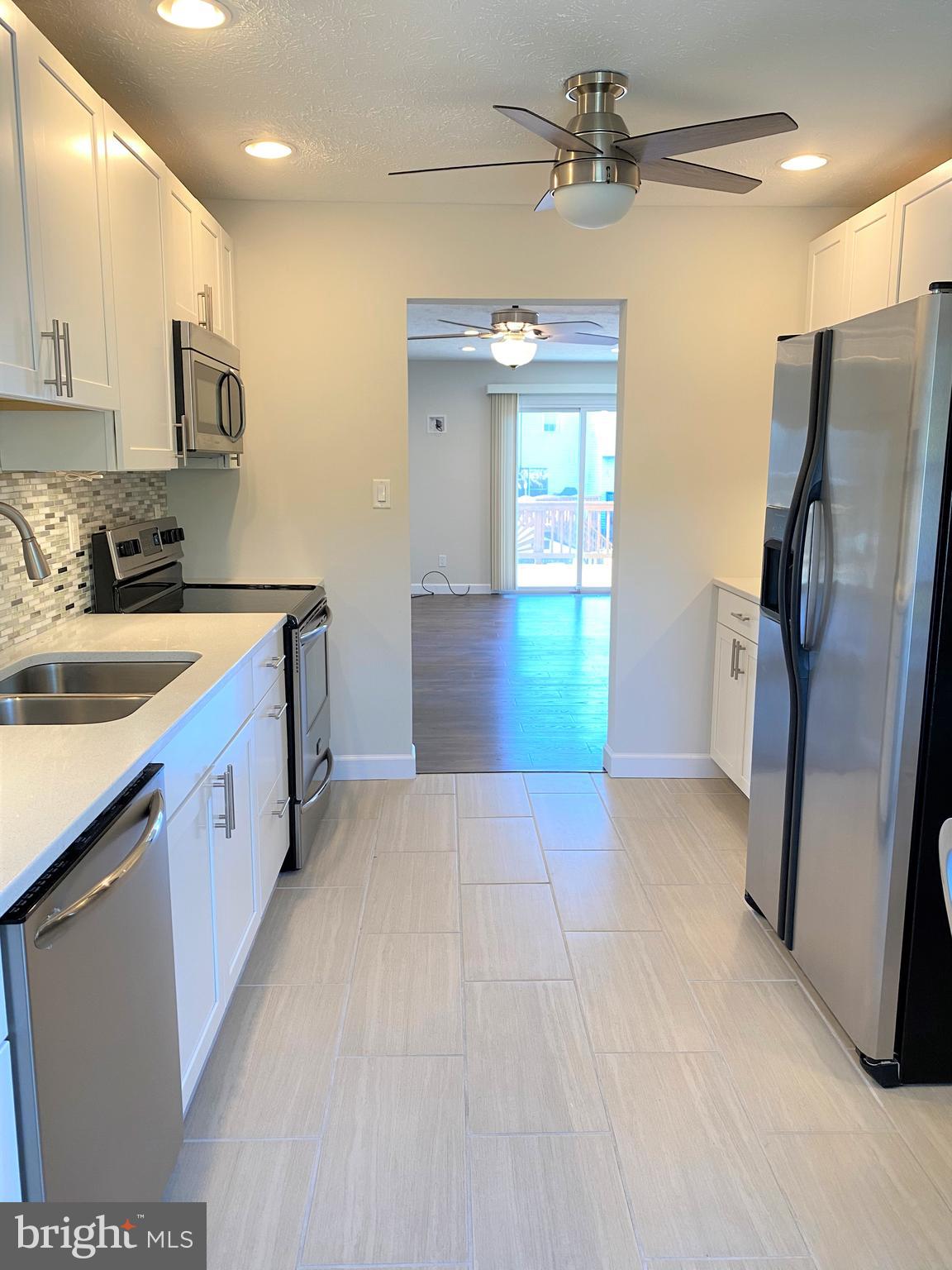 3933 Cutty Sark Road Baltimore, MD 21220 - Photo 27 of 69 a kitchen with stainless steel appliances granite countertop a refrigerator a sink dishwasher a stove with white cabinets