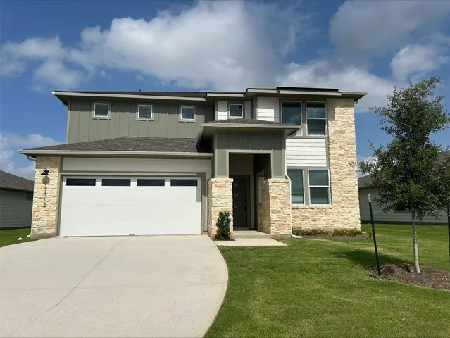 a front view of a house with a garden and yard
