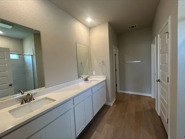 a kitchen with granite countertop a sink a stove top oven a counter space and cabinets