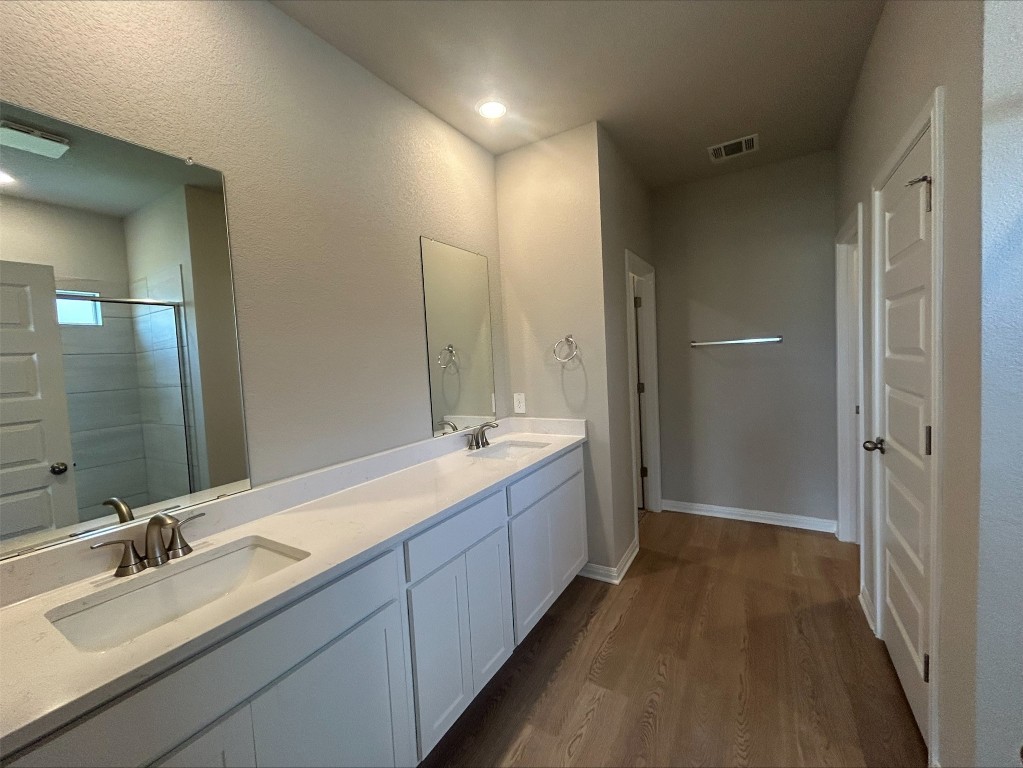 17112 Lomond Way Pflugerville, TX 78660 - Photo 6 of 9 Full bath with wood finished floors, double vanity, and a shower with shower door