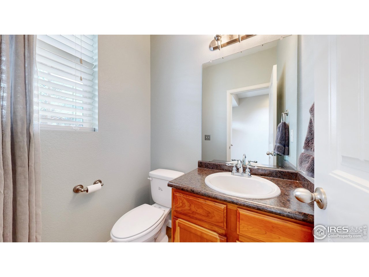 419 Clark Street Johnstown, CO 80534 - Photo 11 of 31 a bathroom with a sink vanity mirror and toilet
