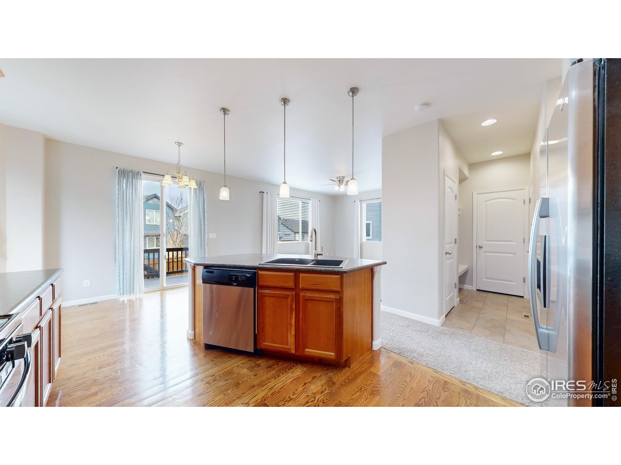 419 Clark Street Johnstown, CO 80534 - Photo 8 of 31 a open living room with stainless steel appliances kitchen island granite countertop a refrigerator and cabinets