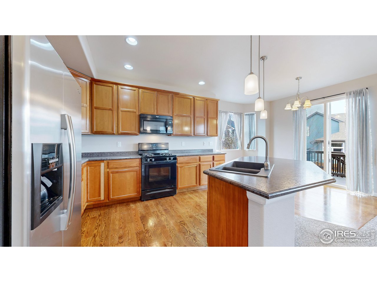 419 Clark Street Johnstown, CO 80534 - Photo 9 of 31 a kitchen with stainless steel appliances granite countertop a sink a stove and a refrigerator