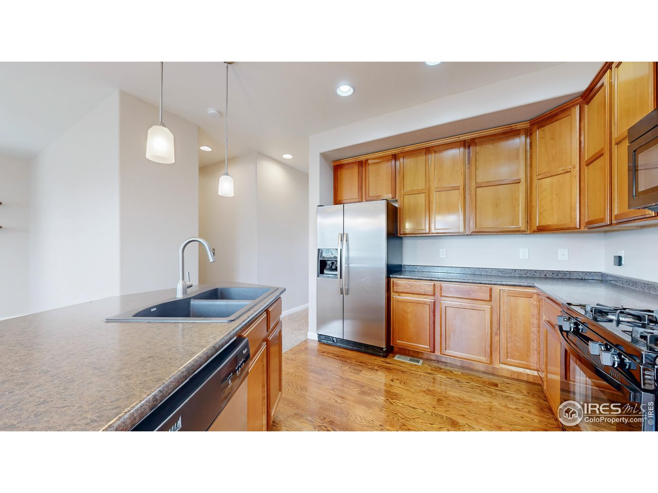 419 Clark Street Johnstown, CO 80534 - Photo 10 of 31 a kitchen with stainless steel appliances granite countertop a sink a stove and a refrigerator