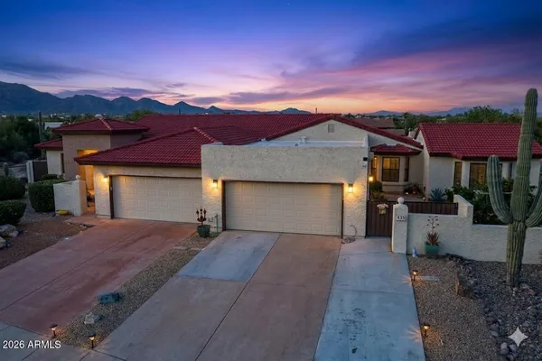 a front view of a house with a yard and mountain view