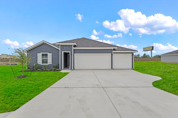 a front view of house with yard and garage