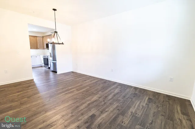 a view of a room with wooden floor a ceiling fan and a window