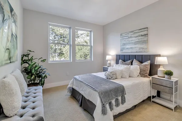 a bedroom with bed and a potted plant