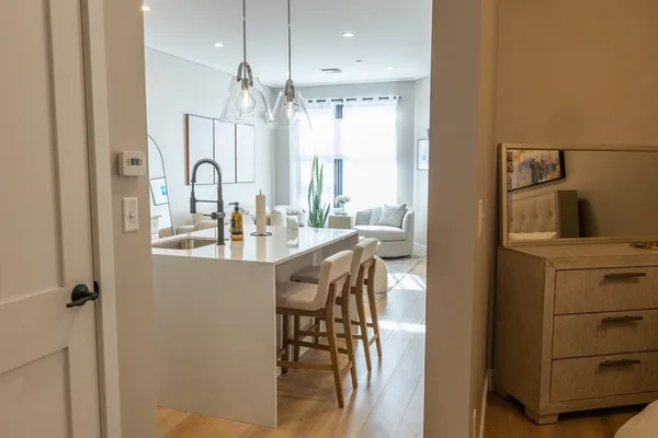 a kitchen with a table chairs refrigerator and cabinets