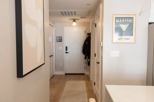 a view of a hallway with a refrigerator and a table