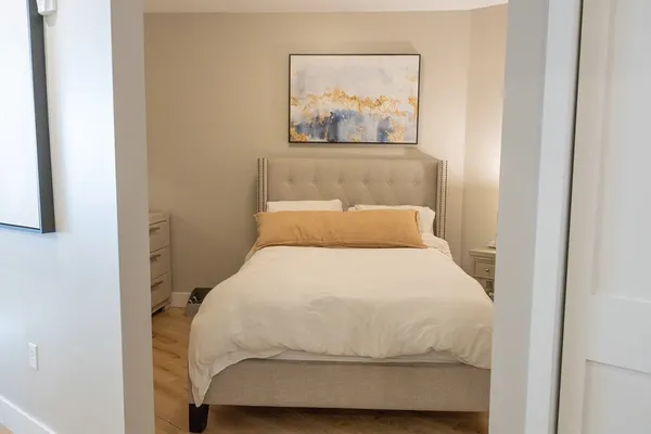 a bedroom with a bed and painting on the wall
