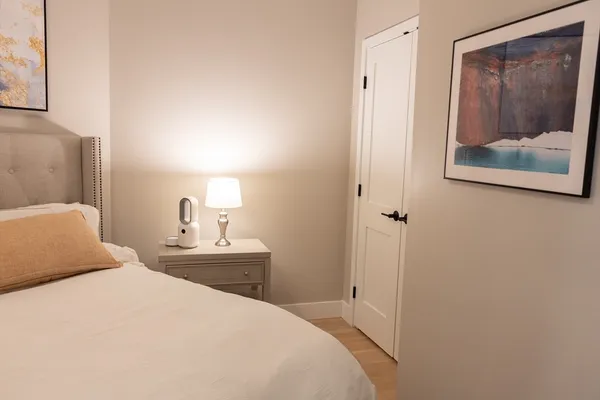 a bedroom with a bed and a painting on the wall