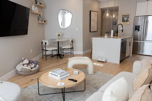 a living room with furniture a flat screen tv and kitchen view