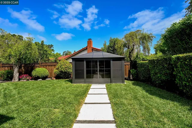 a view of a house with backyard and sitting area