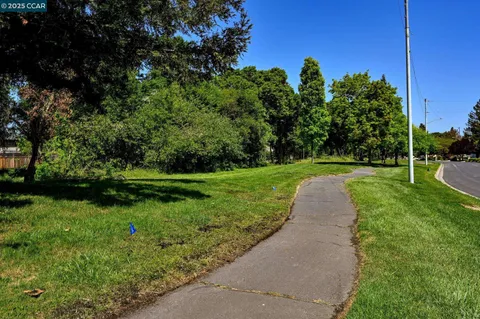 a view of a white house with large windows and a small yard