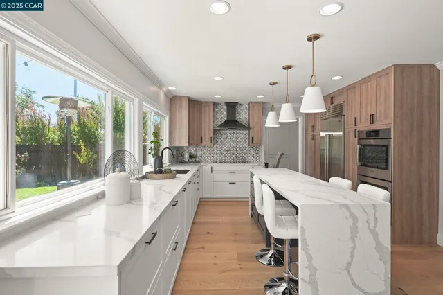 a kitchen with a stove a sink a center island and cabinets