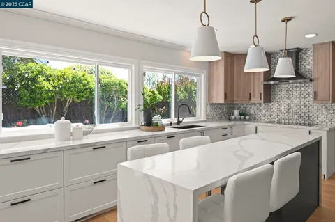 a kitchen with stainless steel appliances kitchen island granite countertop a refrigerator and stove