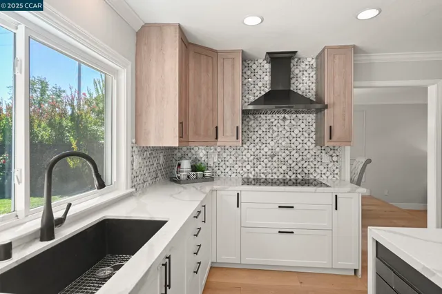 a large kitchen with kitchen island a large window cabinets and stainless steel appliances