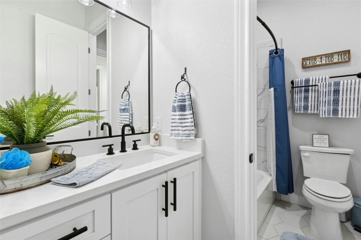 1170 Watterson Road Red Rock, TX 78662 - Photo 22 of 36 a bathroom with a granite countertop sink a toilet and a mirror