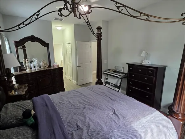 a bedroom with a bed a flat screen tv and a chandelier