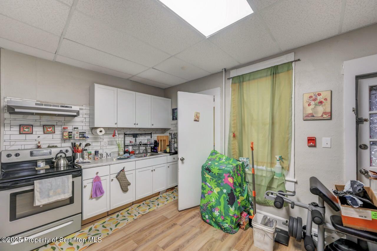 516 Harrison Avenue Scranton, PA 18510 - Photo 33 of 74 a kitchen filled with stainless steel appliances a white stove top oven a refrigerator and a dining table with wooden floor