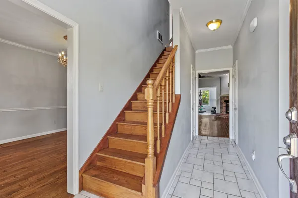 a view of a hallway with wooden floor and staircase