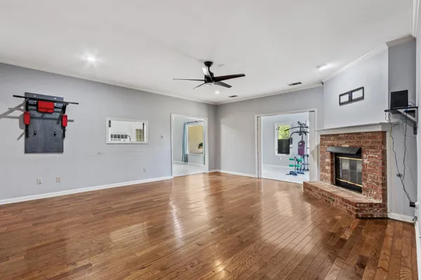 an empty room with fireplace wooden floor and windows