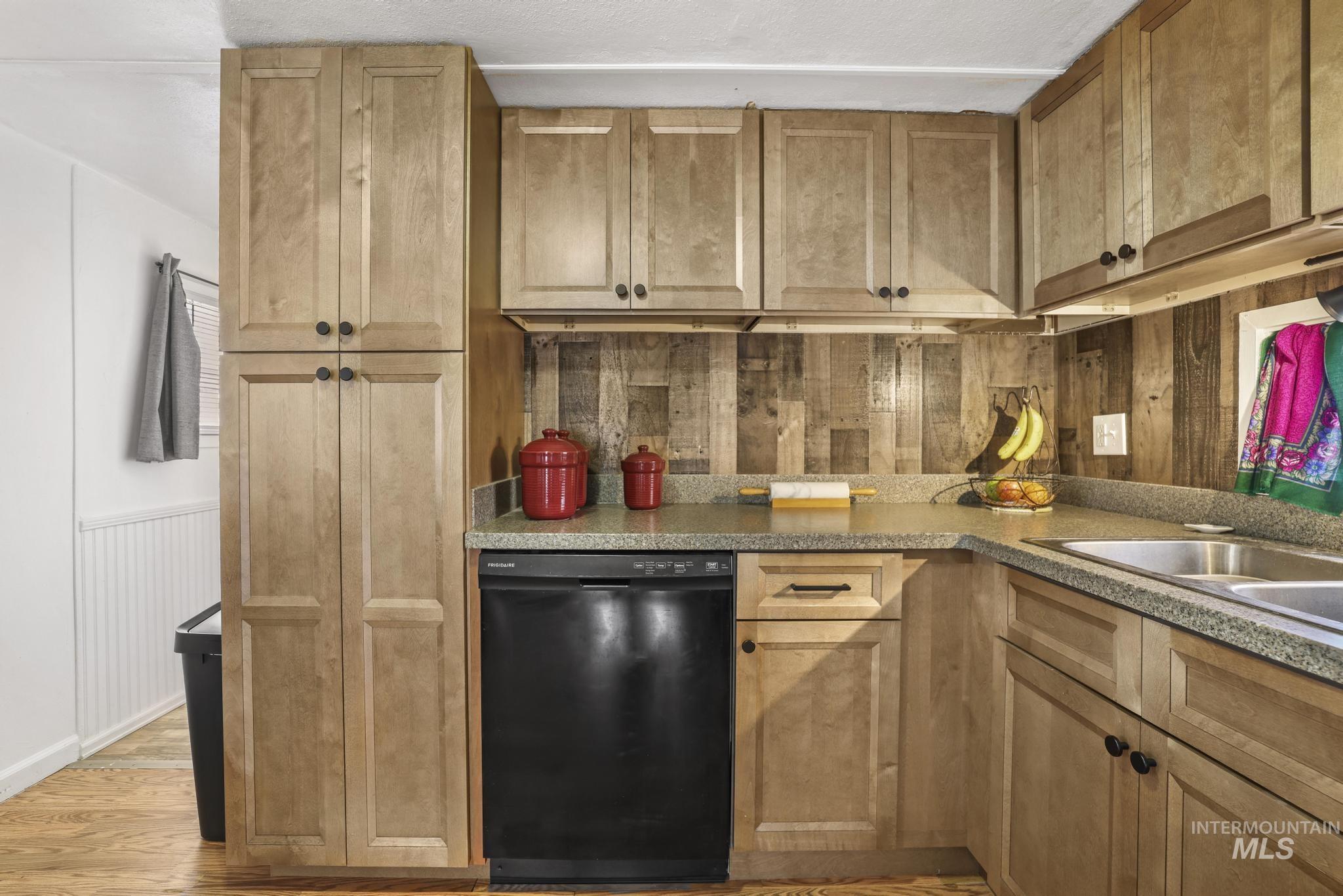 198 South Hills Road, Unit 45 Twin Falls, ID 83301 - Photo 12 of 25 Kitchen featuring dishwasher, light wood-style flooring, a wainscoted wall, and wood walls