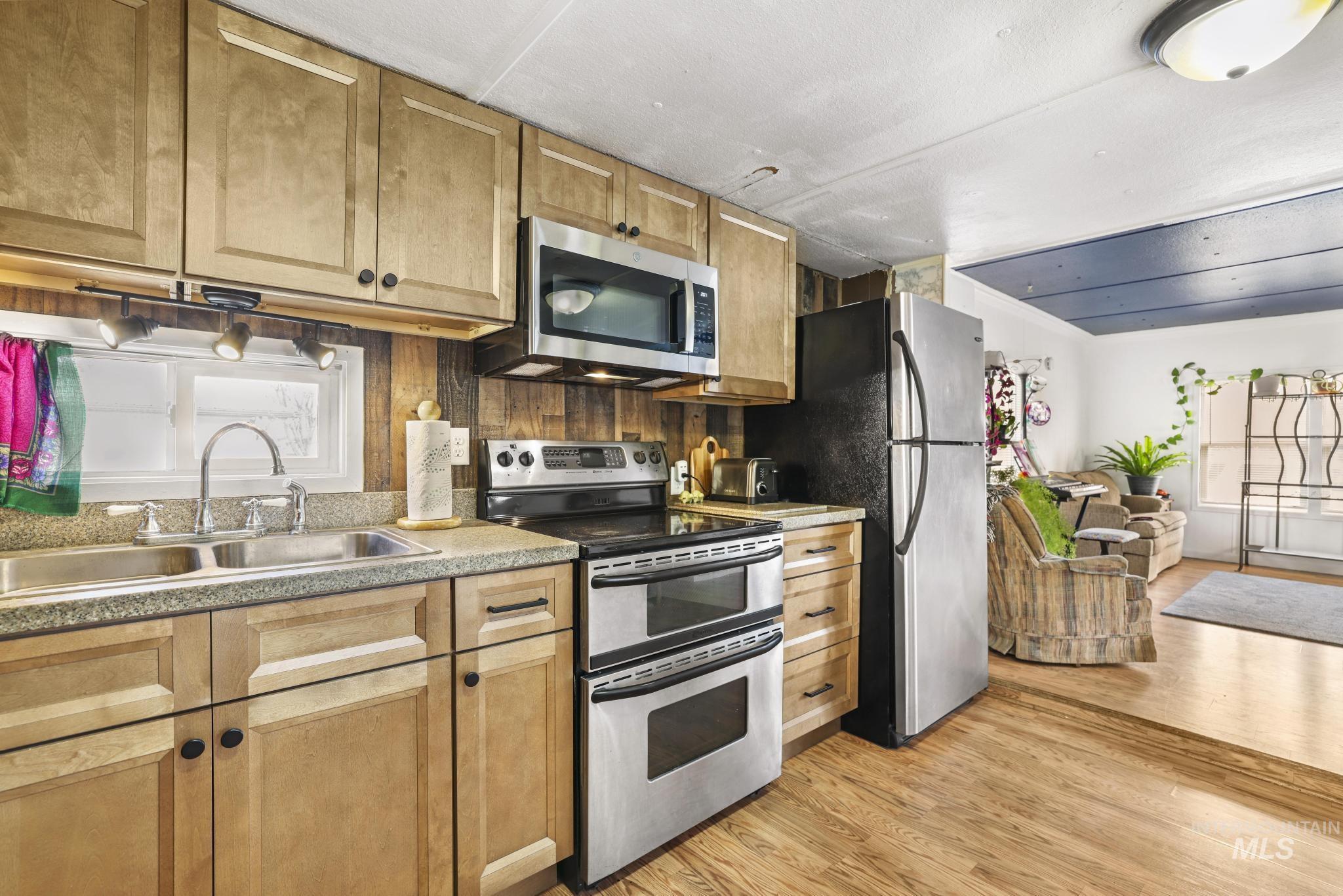 198 South Hills Road, Unit 45 Twin Falls, ID 83301 - Photo 25 of 25 Kitchen with stainless steel appliances, open floor plan, light wood finished floors, and light countertops