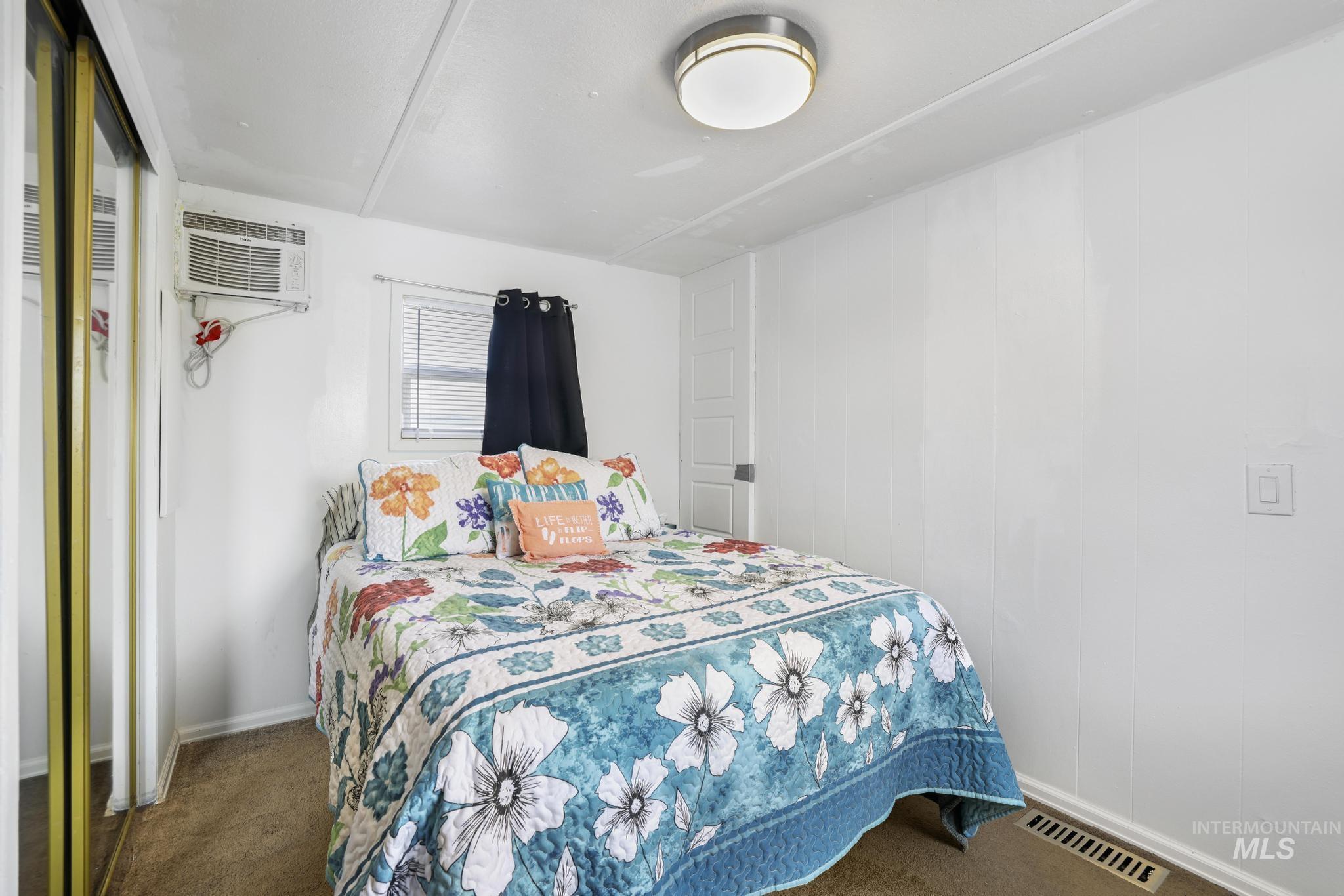 198 South Hills Road, Unit 45 Twin Falls, ID 83301 - Photo 18 of 25 Bedroom with dark colored carpet and a wall unit AC