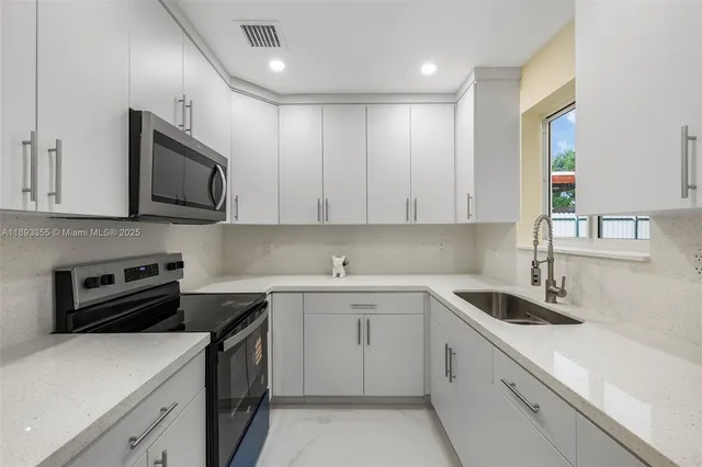 a kitchen with a sink stove and microwave