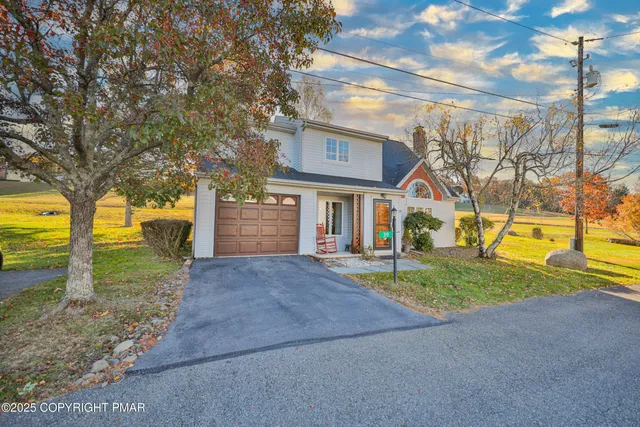 a view of a house with backyard and a tree