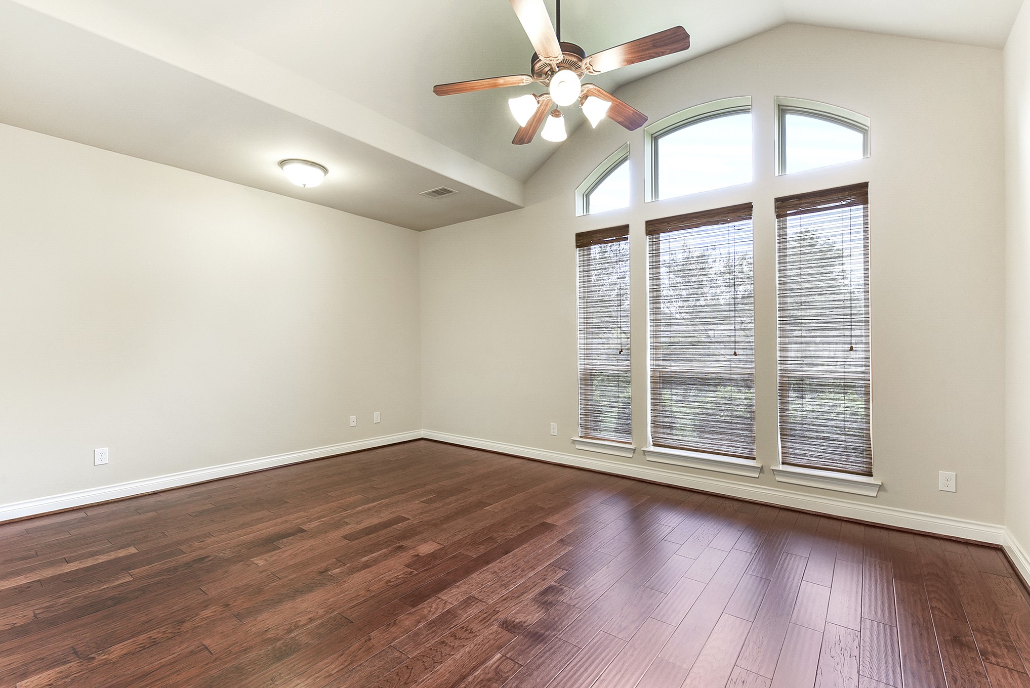 29023 Powder Ridge Drive Katy, TX 77494 - Photo 22 of 50 Step into luxury in the spacious primary bedroom, conveniently located on the main floor and offering beautiful views of the backyard. This inviting retreat provides plenty of room for a comfortable seating area, creating the perfect space to relax and unwind. The expansive layout features beautiful wood flooring and a drop-down ceiling fan, adding both style and comfort to this private retreat.