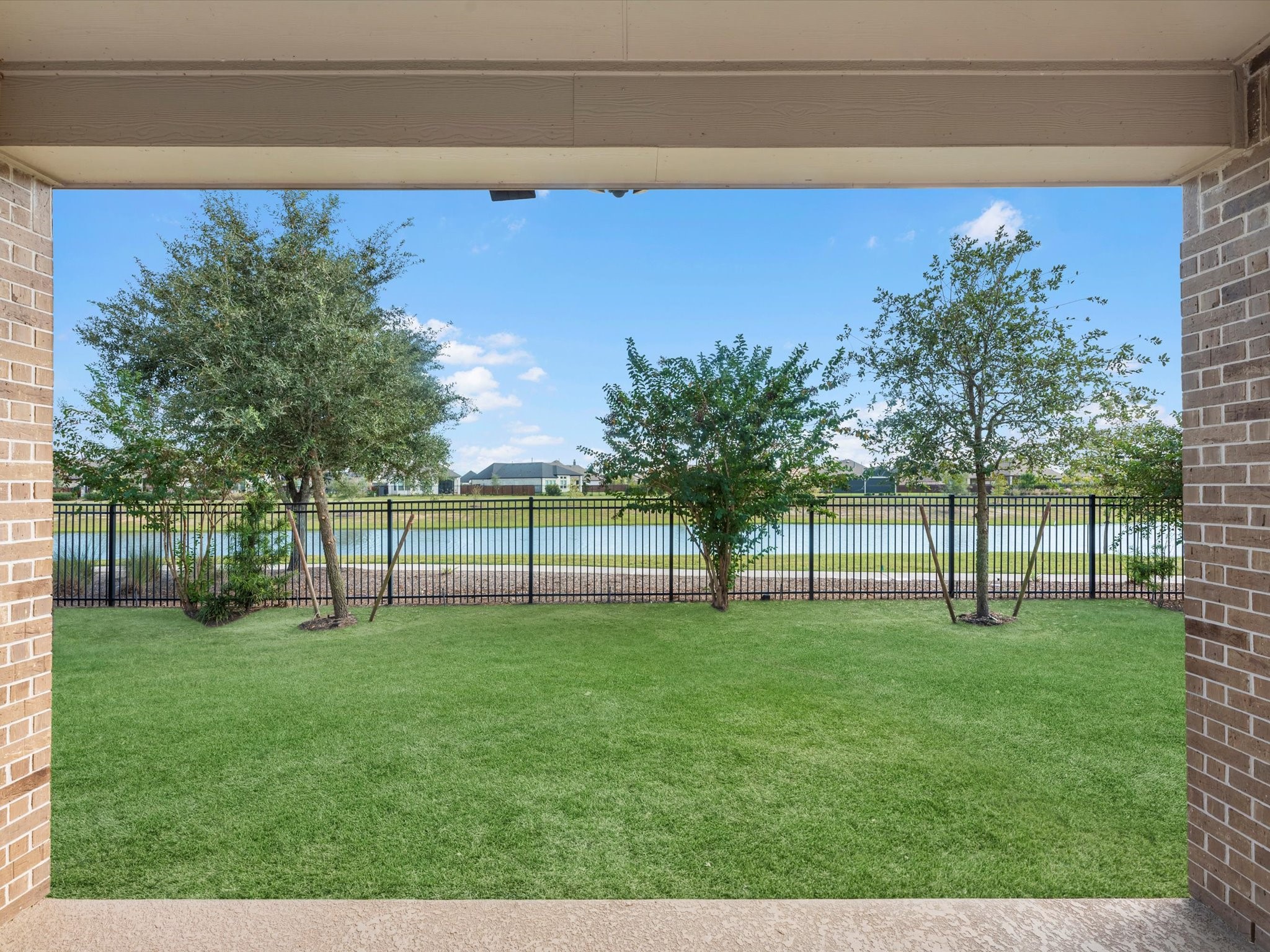 10135 Napier Drive Rosharon, TX 77583 - Photo 27 of 36 View from the covered patio overlooking the spacious backyard, tranquil water view, and walking path just beyond.