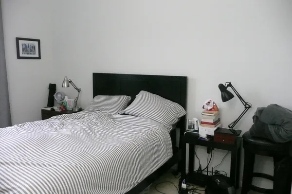 a bedroom with a bed and a flat tv screen on dresser
