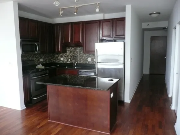 a kitchen with granite countertop wooden cabinets and a stainless steel appliances