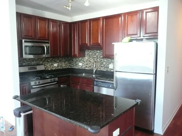 a kitchen with a refrigerator a stove a sink and a window