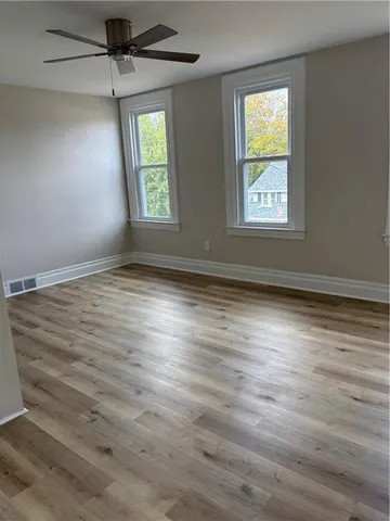 wooden floor in an empty room with a window