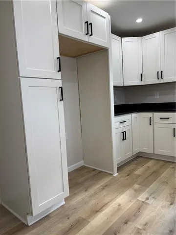 a kitchen with white cabinets and white appliances