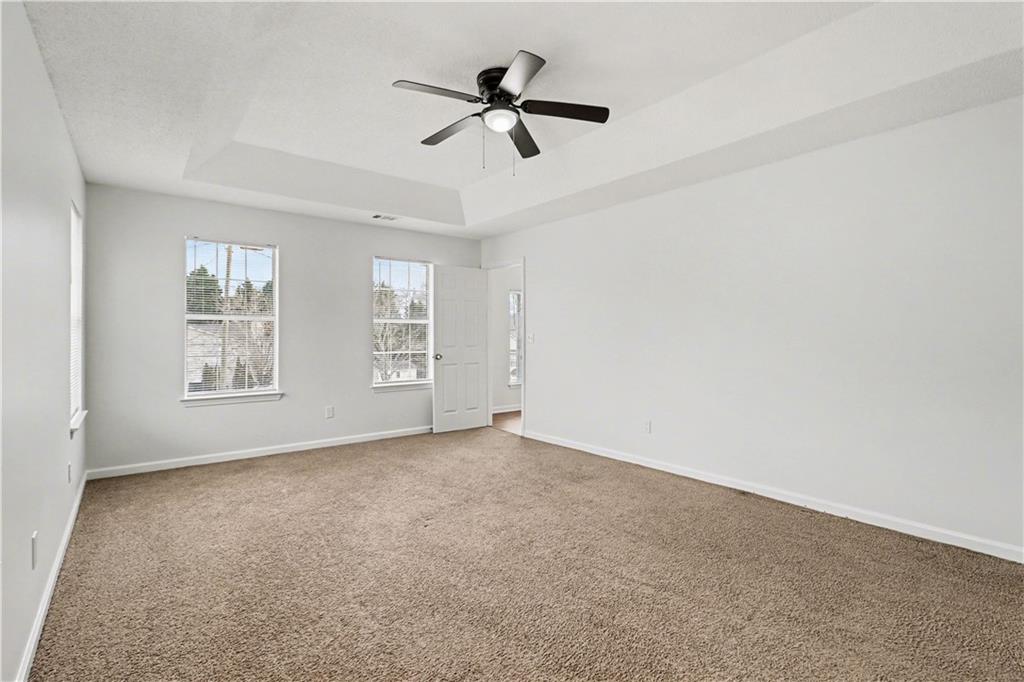 6236 Springwater Lane Lithonia, GA 30058 - Photo 15 of 23 an empty room with ceiling fan and windows