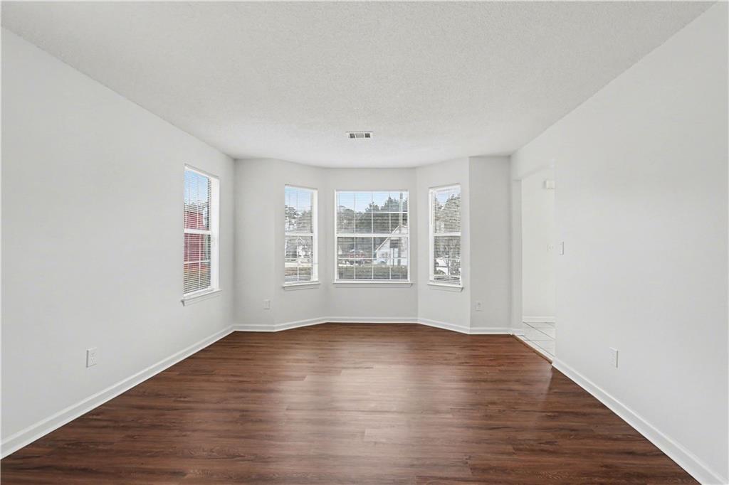 6236 Springwater Lane Lithonia, GA 30058 - Photo 4 of 23 a view of an empty room with wooden floor and a window