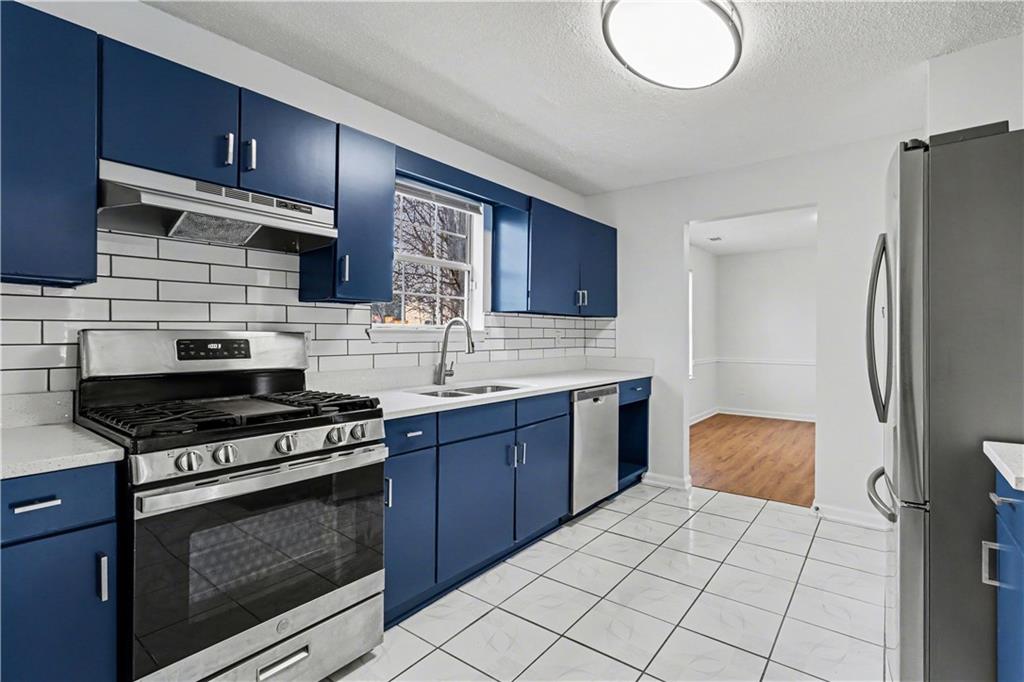 6236 Springwater Lane Lithonia, GA 30058 - Photo 8 of 23 a kitchen with stainless steel appliances wooden cabinets and a stove top oven