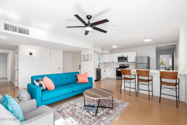 a living room with furniture kitchen view and a window