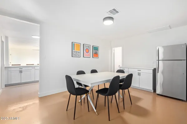 a view of a dining room with furniture and a refrigerator