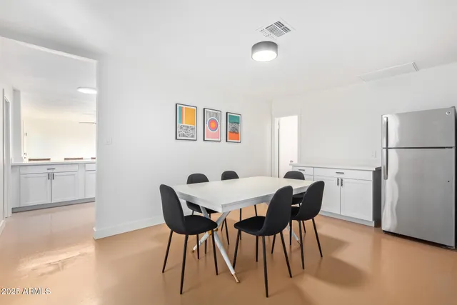 a view of a dining room with furniture and a refrigerator