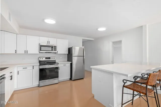 a kitchen with stainless steel appliances a stove refrigerator sink and cabinets