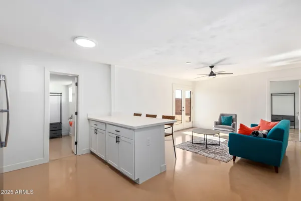 a large white kitchen with a stove a sink dishwasher and a refrigerator with wooden floor