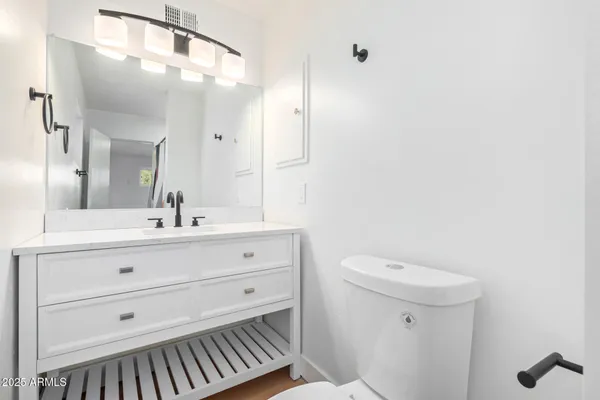 a bathroom with a toilet a sink a mirror and vanity